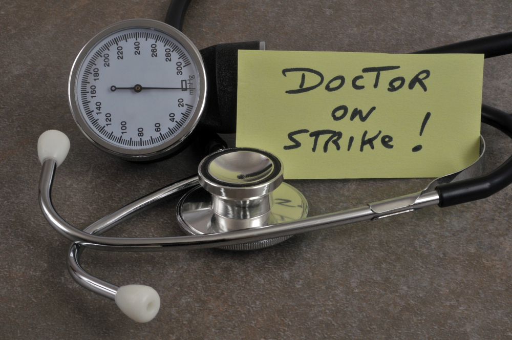 Doctor on strike written on a paper surrounded by medical instruments.//Depositphotos